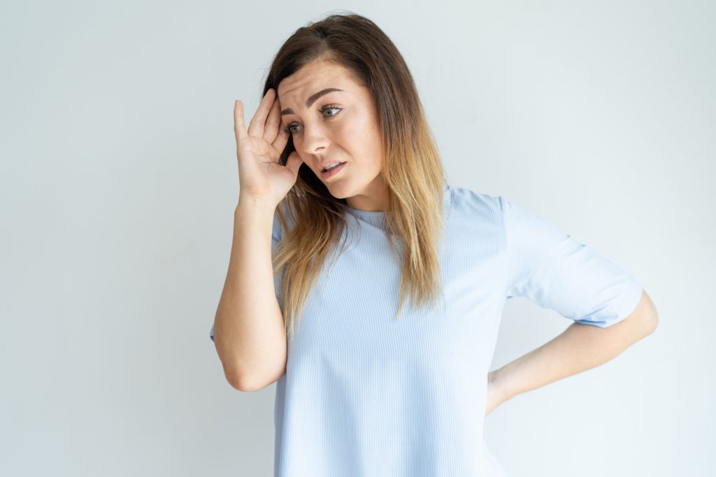 Stressed pretty woman touching head and looking away. Tired middle-aged lady. Problem concept. Isolated front view on white background.